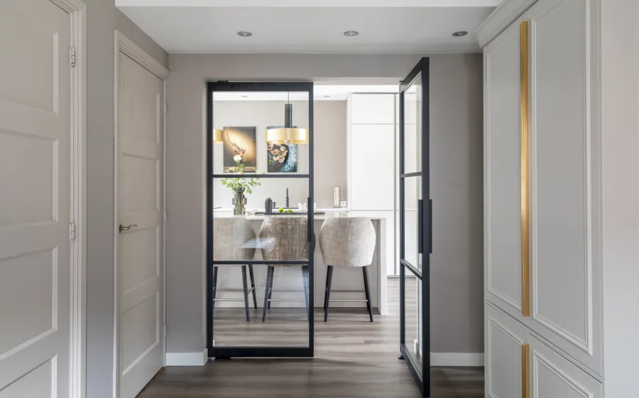 Dubbele stalen taatsdeuren in de hal van een klassiek ingerichte woning.