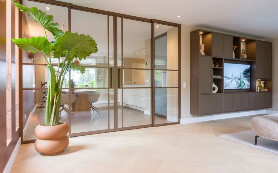 Lindura visgraat vloer in lichte hout tint met bronze stalen deuren en cinewall in de woonkamer