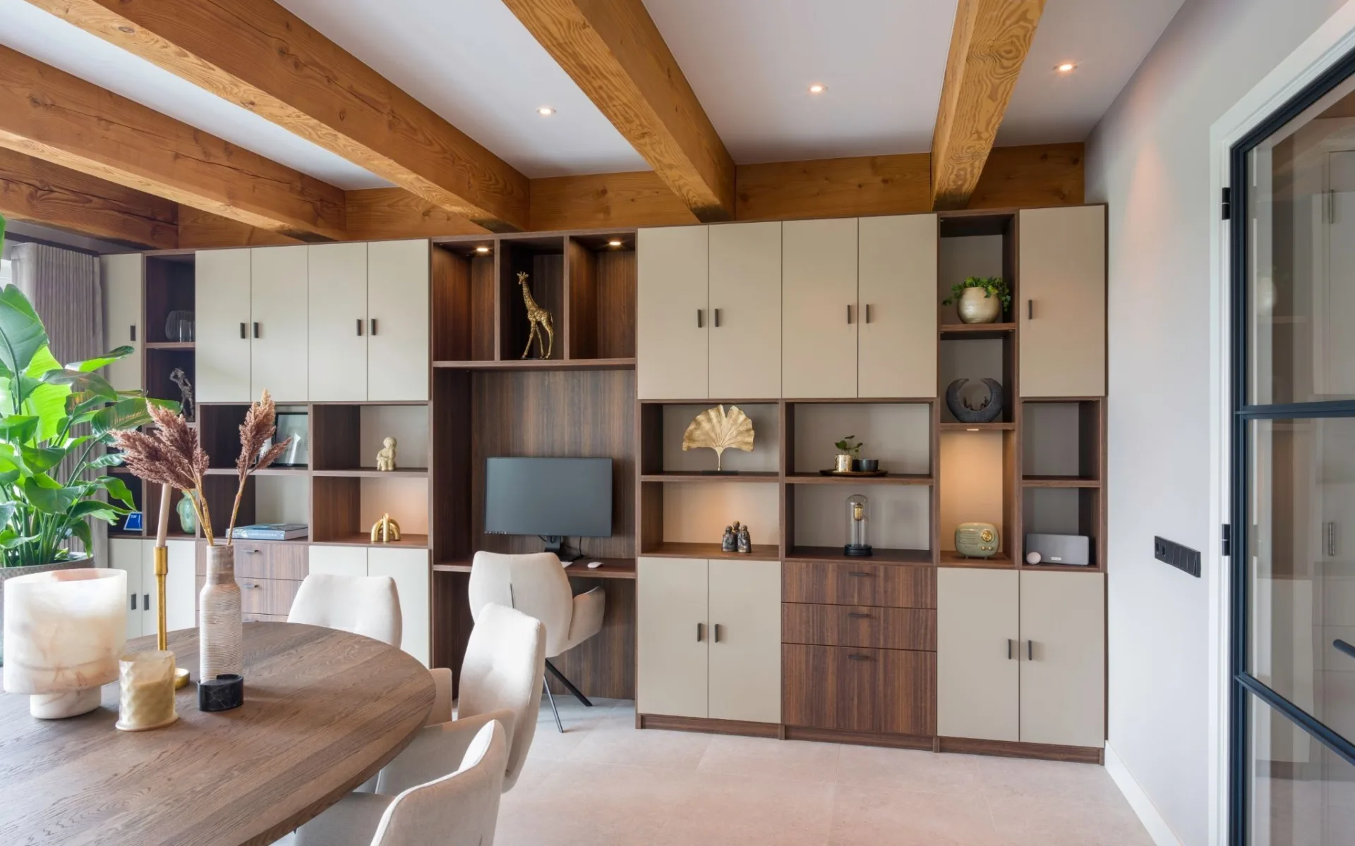 Woonkamer met kastenwand op maat, basiskleur warm walnoot houtlook, kastdeuren en open vakken voor accessoires  Aanhuis.nl