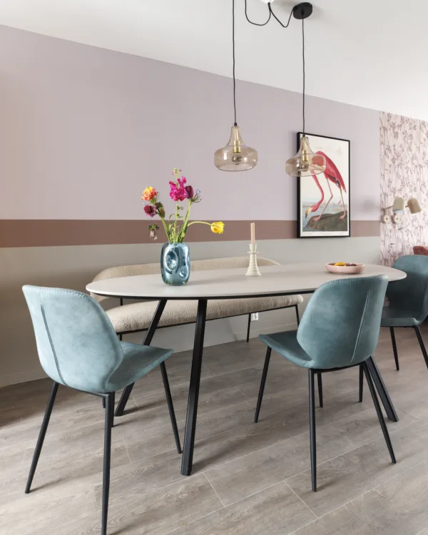 Stijlvolle eetkamer met een houtlook laminaatvloer en een ovale eettafel.