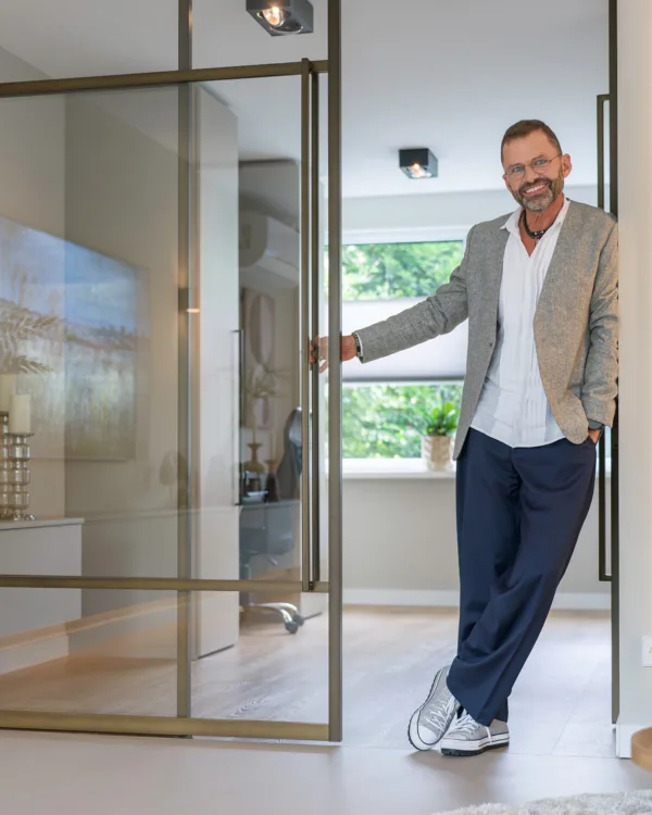 Frans Uyterlinde bij de bruine metalen deur in de woonkamer