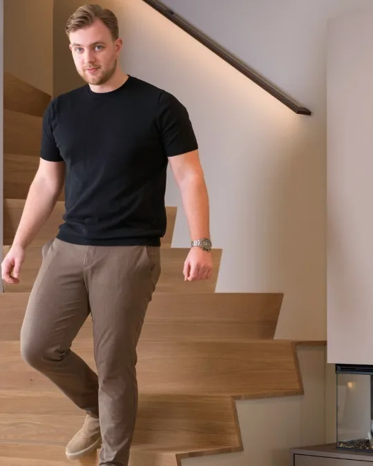 Houten trap met led trapleuning in zwart met led verlichting naar beneden voor goed zicht op alle traptreden.