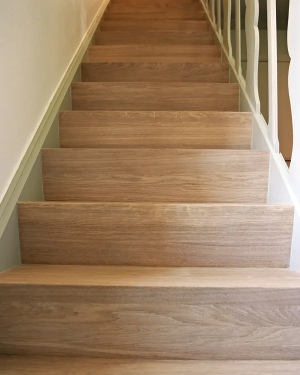 Detail traprenovatie met Z-trap design in warme houtkleur. Aanhuis.nl