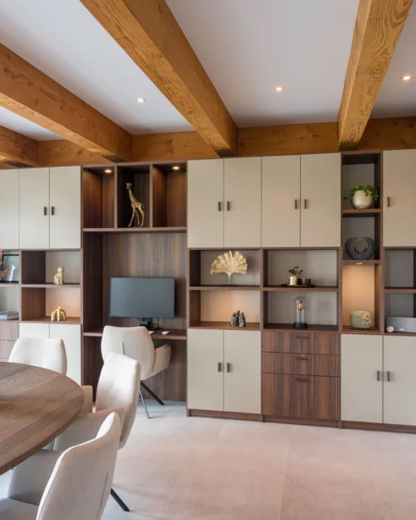 Woonkamer met kastenwand op maat, basiskleur warm walnoot houtlook, kastdeuren en open vakken voor accessoires  Aanhuis.nl