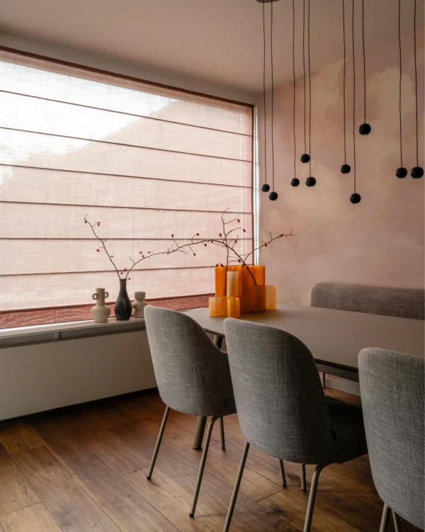 Warm kleurrijk interieur met oude roze vouwgordijnen in eethoek met wolkerig behang