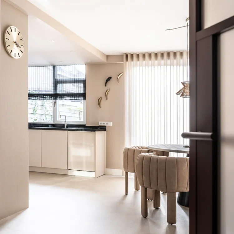 Witte keuken met transparante gordijnen en licht doorlatende rolgordijnen.