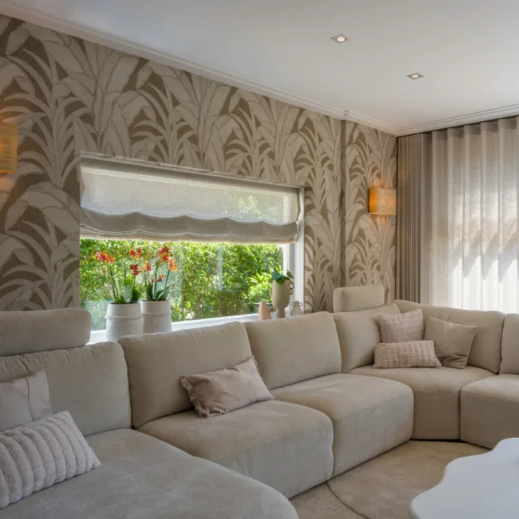 Uniek behang met organische vormen in natuurlijke kleuren, passend bij de woonkamer in wit en beige tinten.