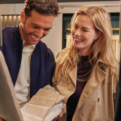 Twee mensen met gordijnen stalen in een Aanhuis.nl winkel