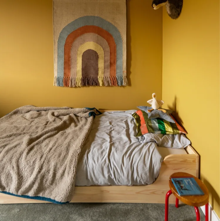Gele muren en plafond in kinderkamer met lichtgroen tapijt